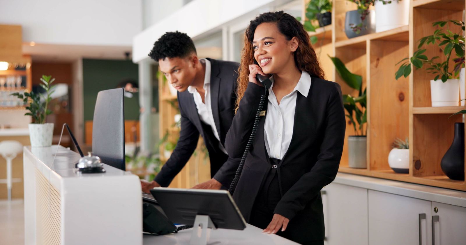 Recepcionistas de hotel usando Silex PMS en la recepción
